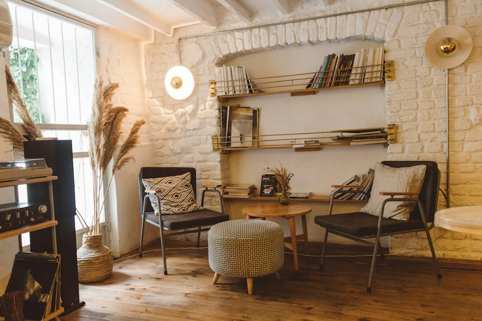 Espace lecture composé de fauteuils, d'une petite table et d'étagères remplies de livres