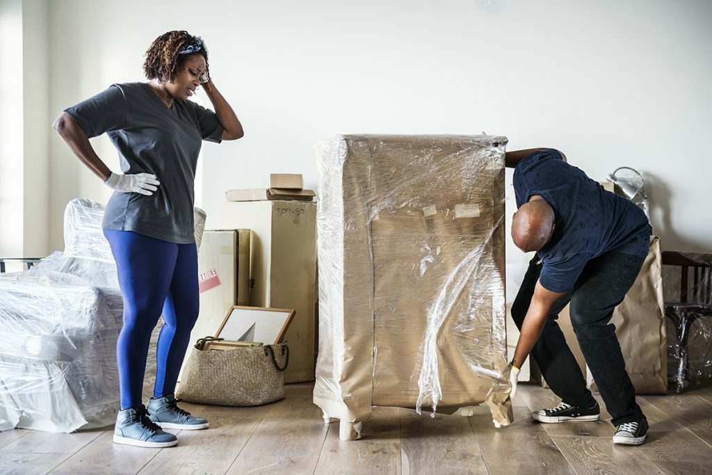 Un homme et une femme désespérés essayant de déménager des meubles seuls
