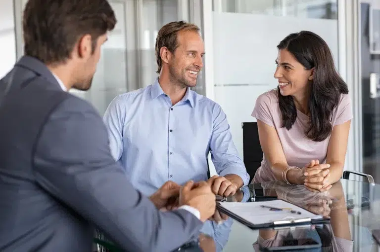Un couple heureux face à un courtier en déménagement
