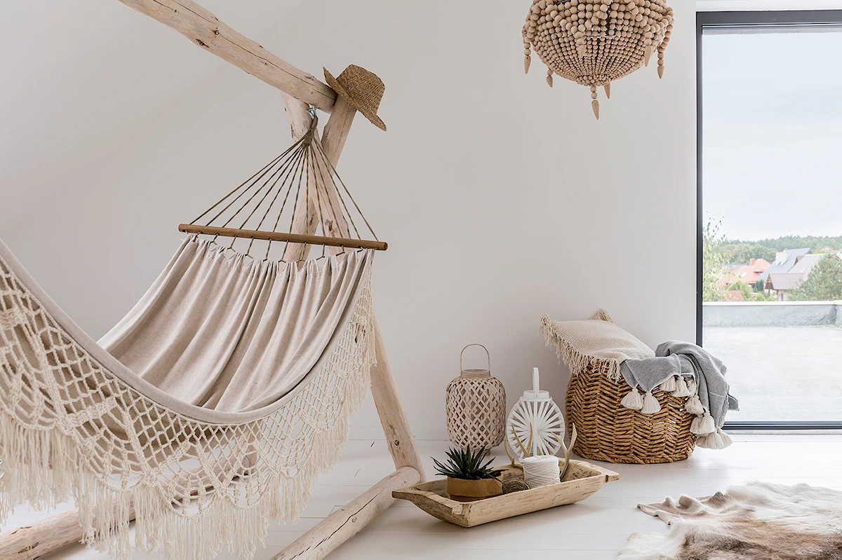 Hamac en croché suspendu à du bois flotté au milieu du salon pour une ambiance naturelle et bohème