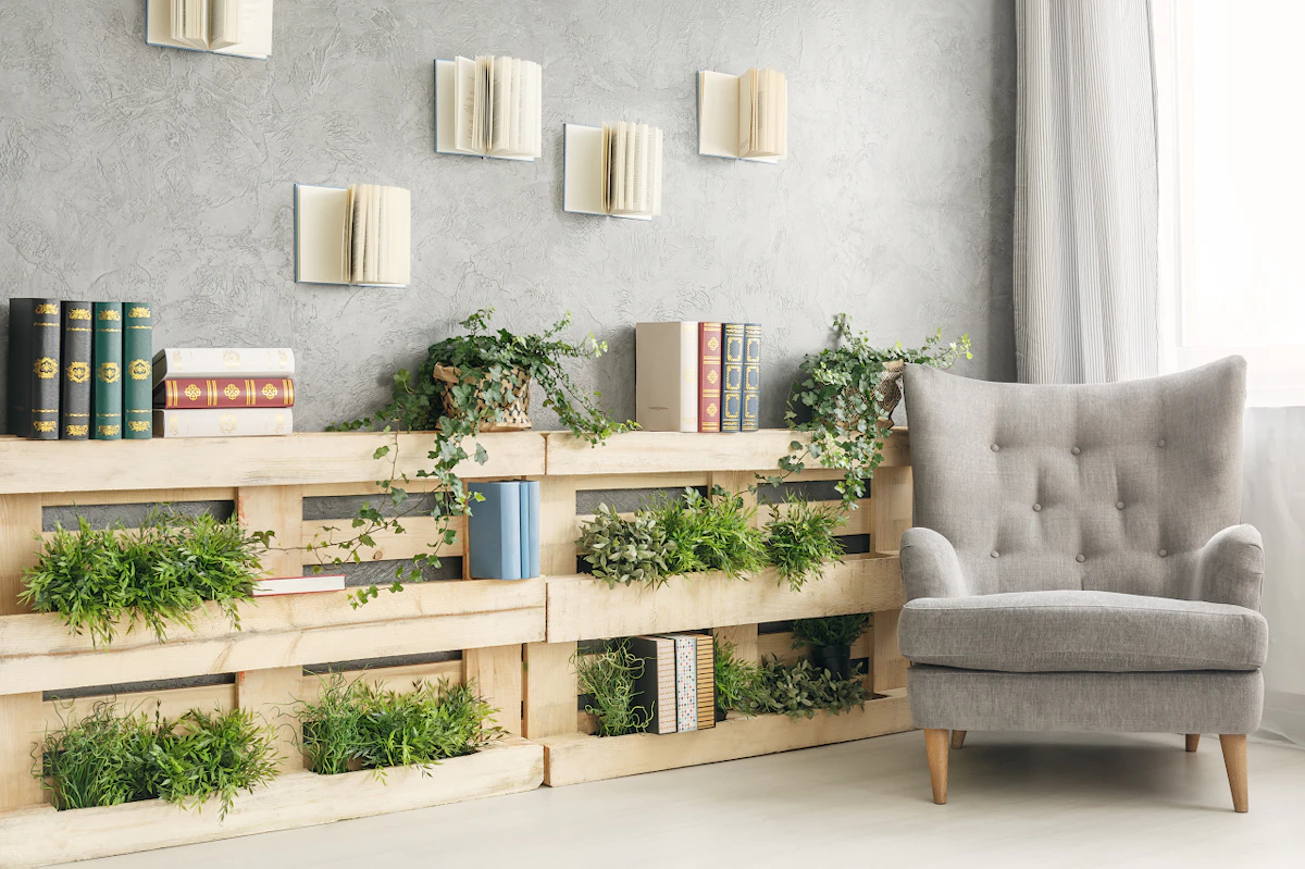 Un fauteuil gris près d'une bibliothèque en palettes de bois