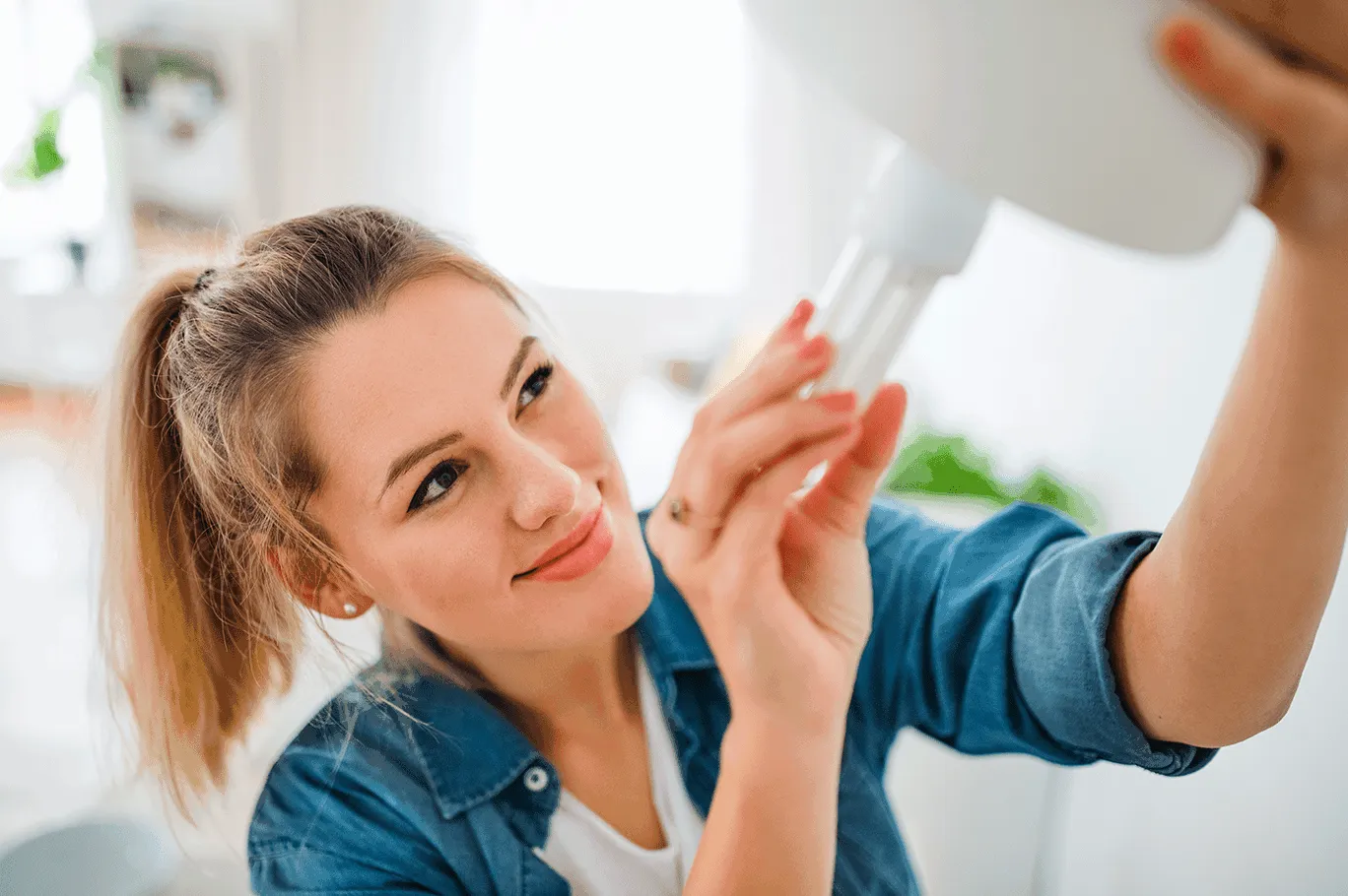 Une femme change une ampoule