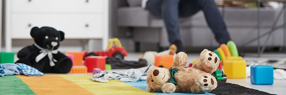 Jouets et peluches éparpillés au sol dans le salon