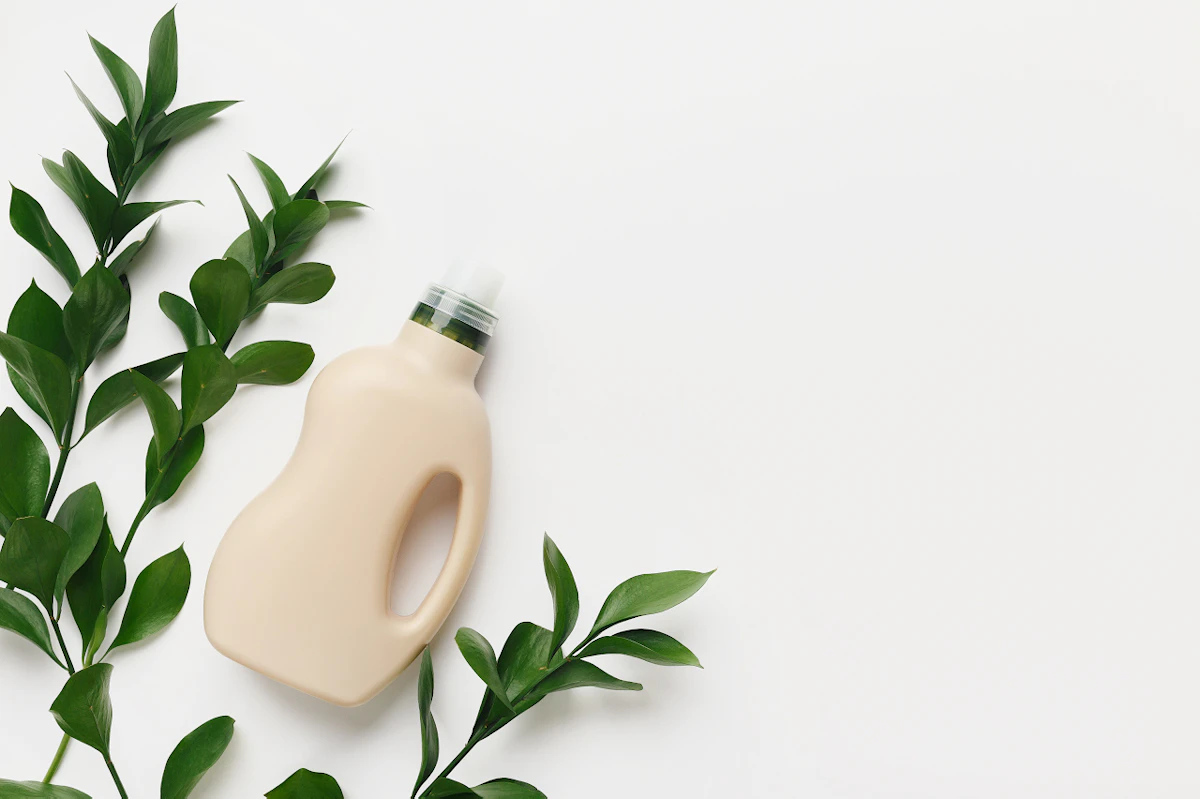 Bidon de lessive avec des branches sur fond blanc
