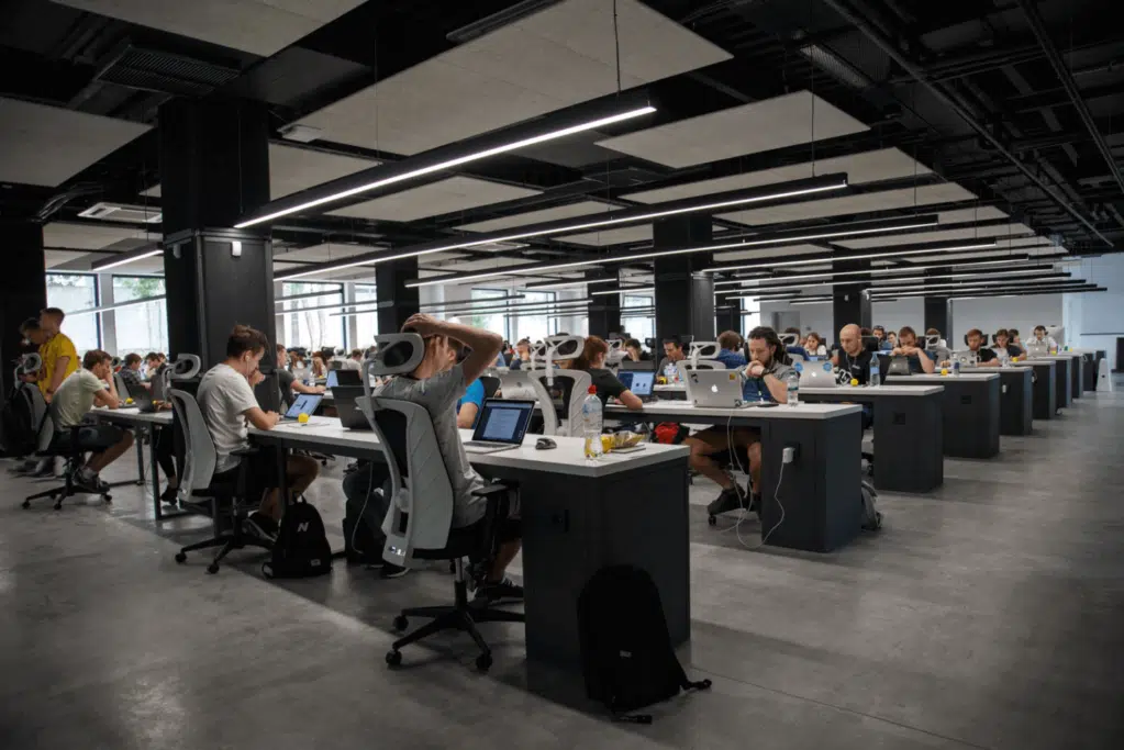 An open-plan office filled with people working on their laptops