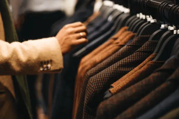 A person is looking at jackets on a rack