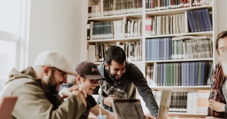 Young people laughing in front of their laptop screens