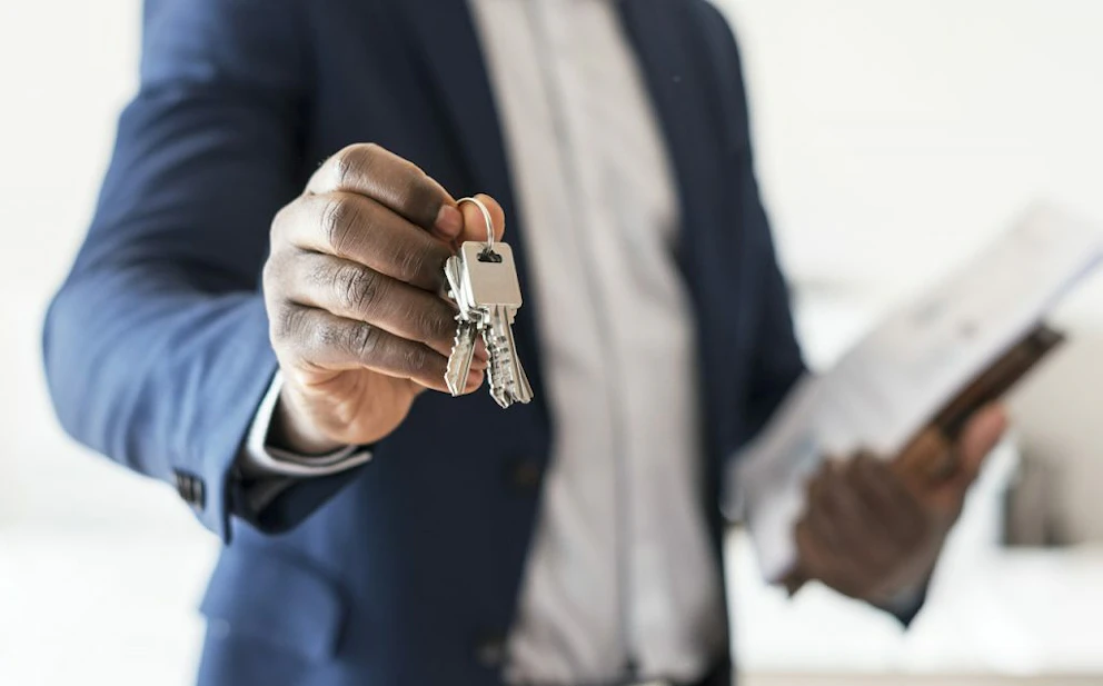 Un expert en costume tend des clefs de maison