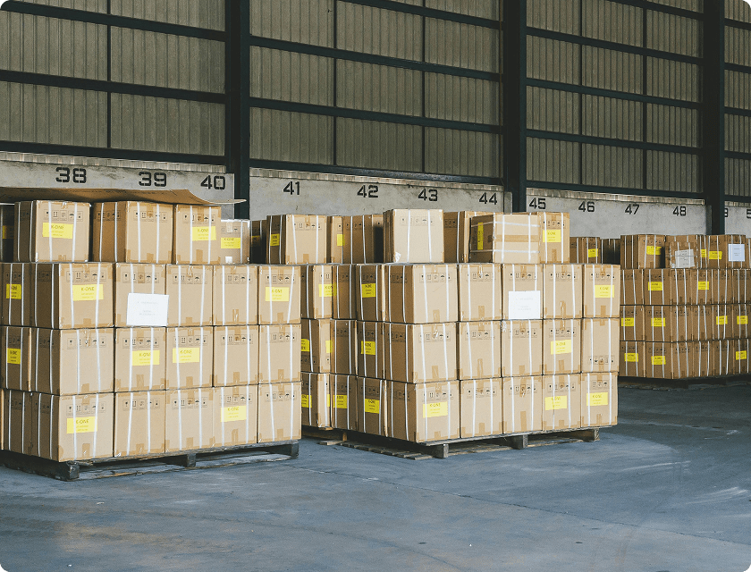 Pallets stacked with cardboard boxes in a warehouse.