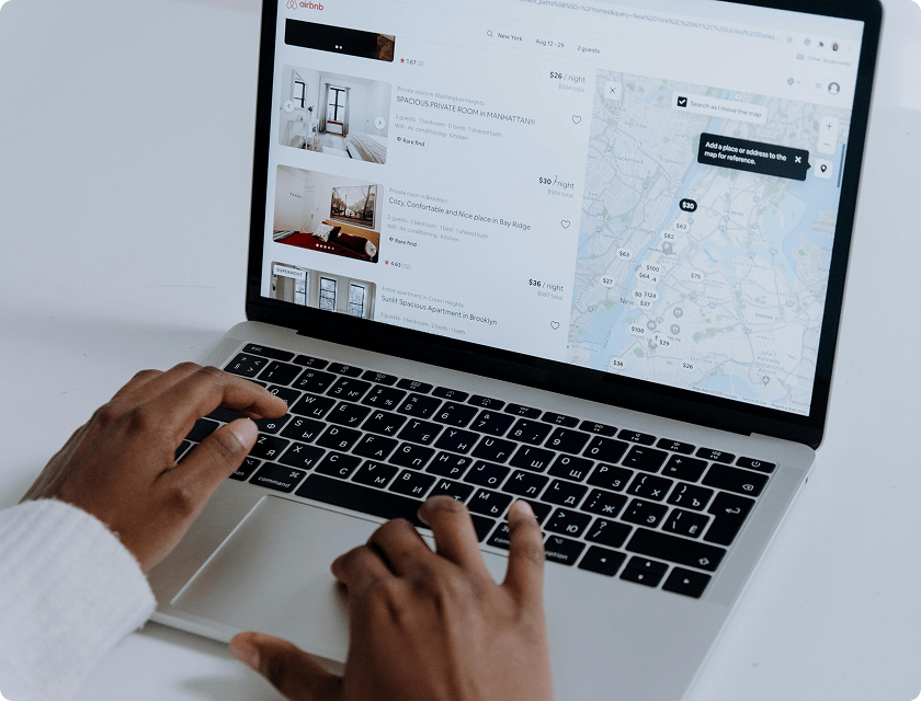 A laptop screen showing a search on the Airbnb website.