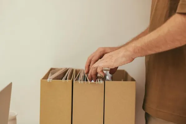 Un homme recherche un document parmi des dossiers classés
