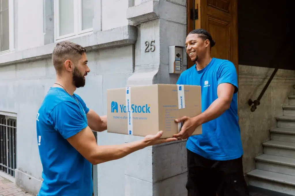 Déménageurs YouStock se transmettant un carton