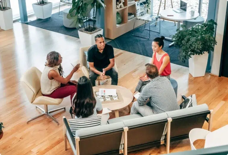5 collaborateurs réunis autour d'une table pour discuter
