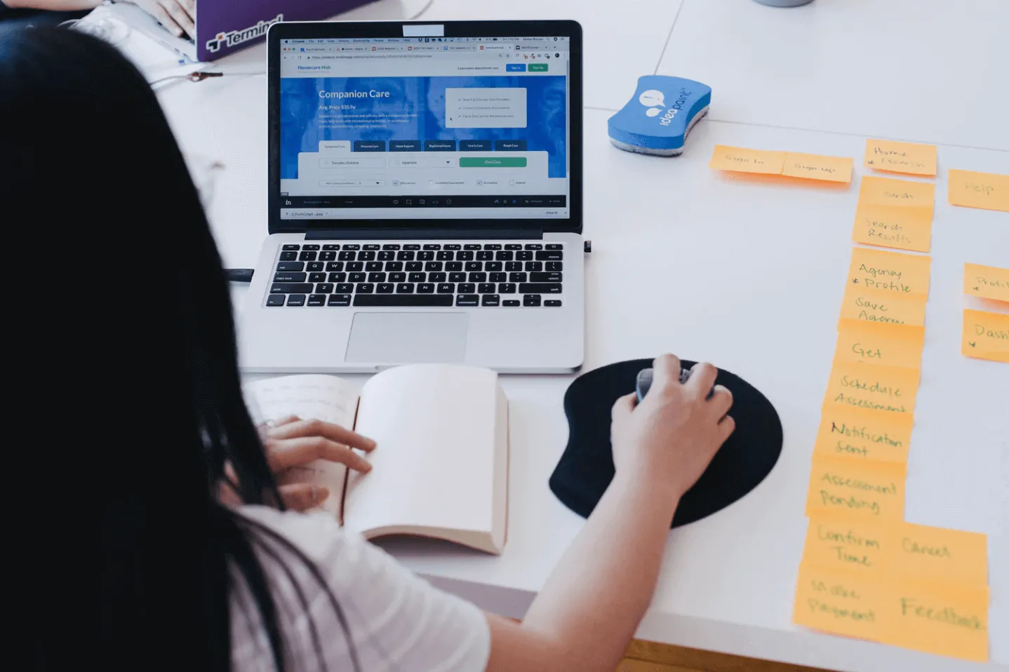 Young woman working on her laptop next to lots of sticky notes