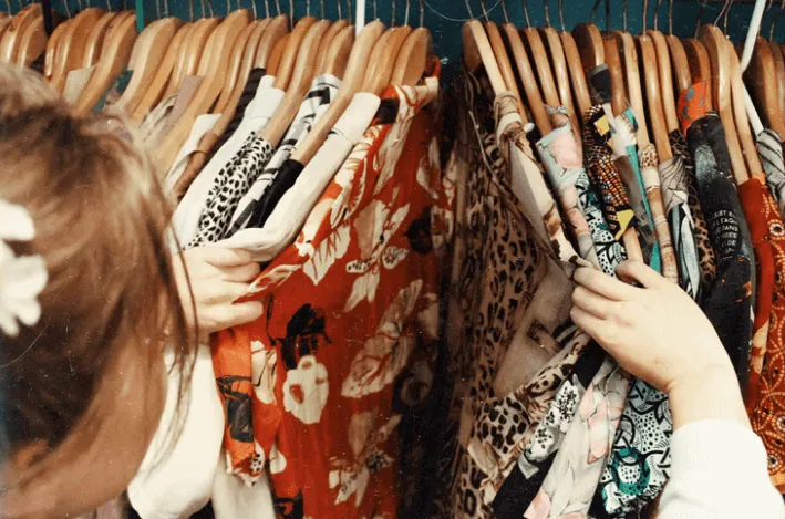 Woman Looking at Clothes on Hangers