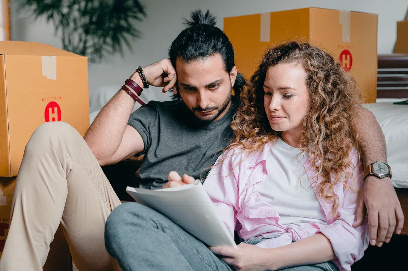 Un couple prenant des notes au milieu de cartons de déménagement