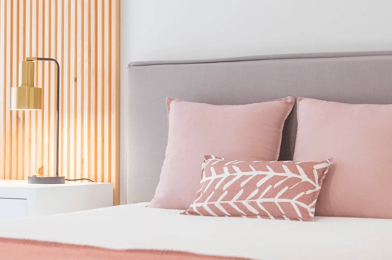 Un lit dans une chambre moderne en rose, blanc et bois