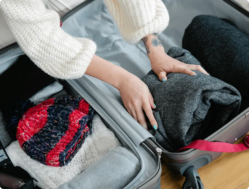 A woman is packing her suitcase