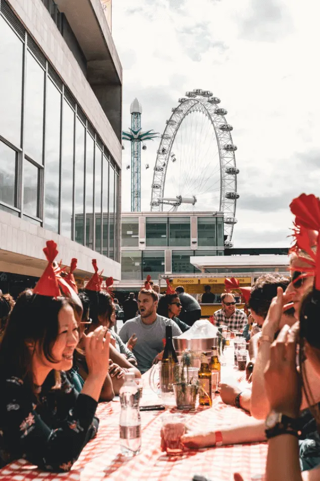 people dining outside near ferris wheel