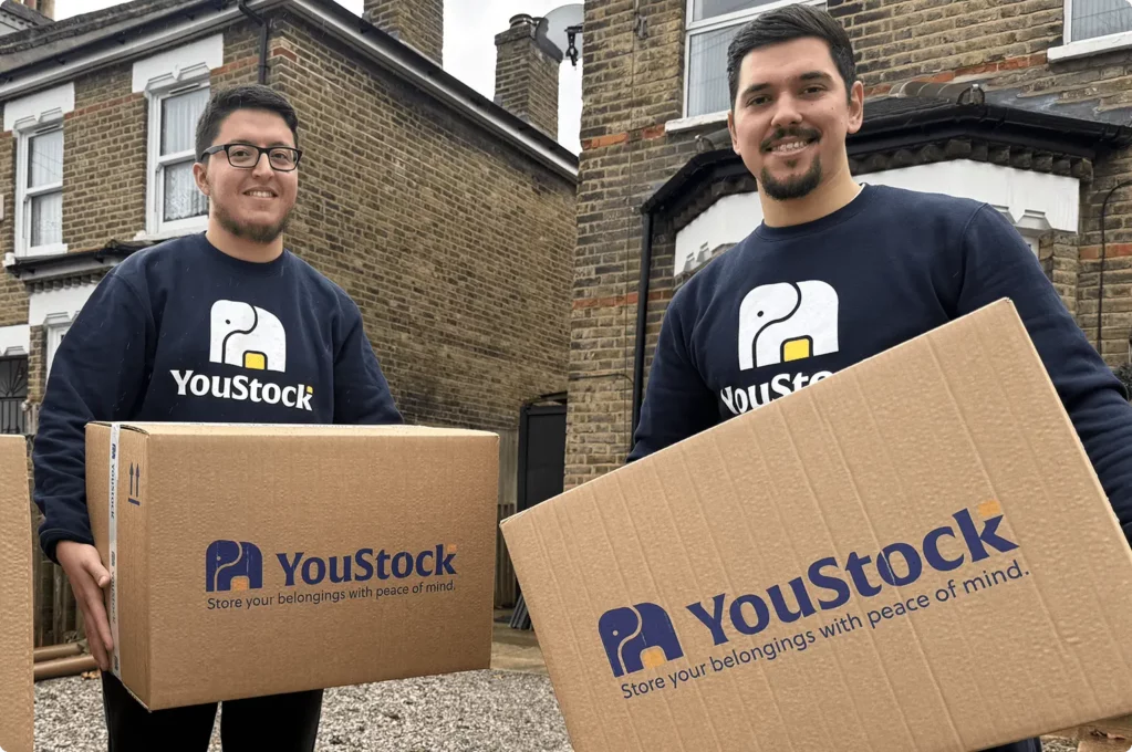 Two YouStock movers holding a storage box