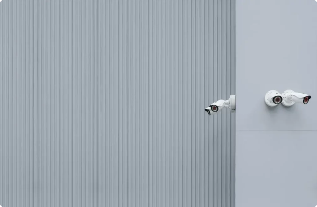 4 security cameras at the corner of a warehouse