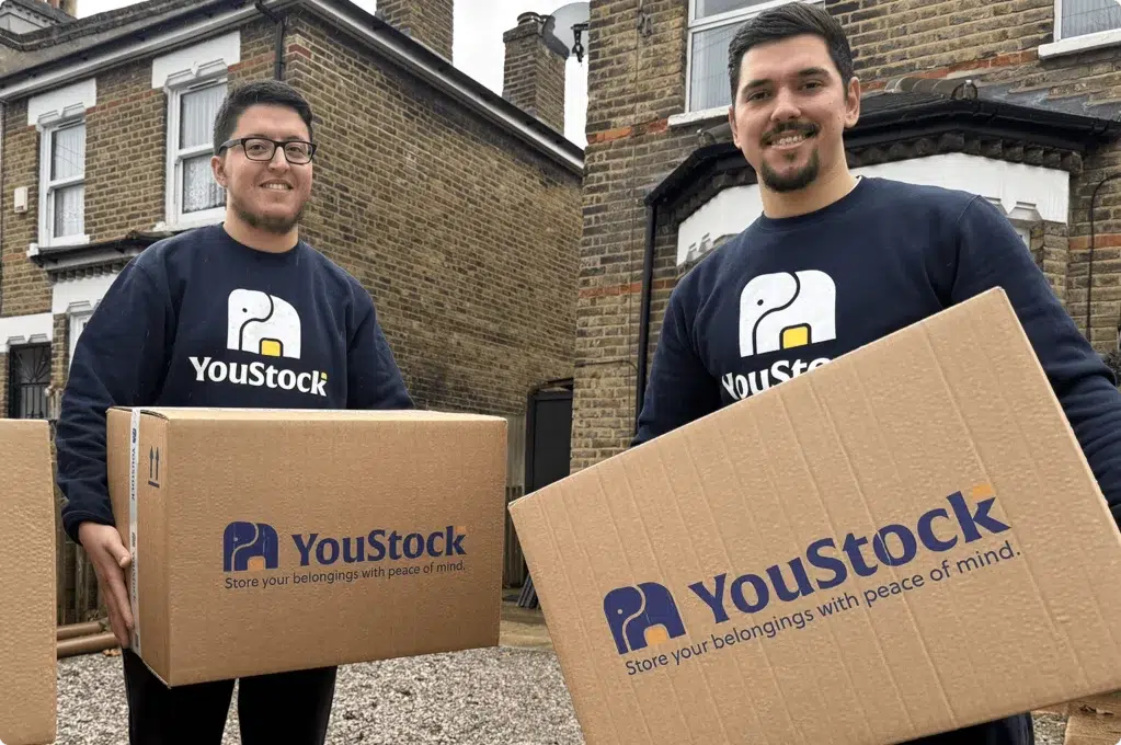 Two YouStock movers holding a storage box