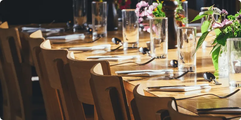 Table de restaurant dressée avec des courverts et de fleurs