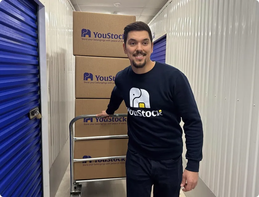 A YouStock expert pulls a trolley filled with storage boxes.