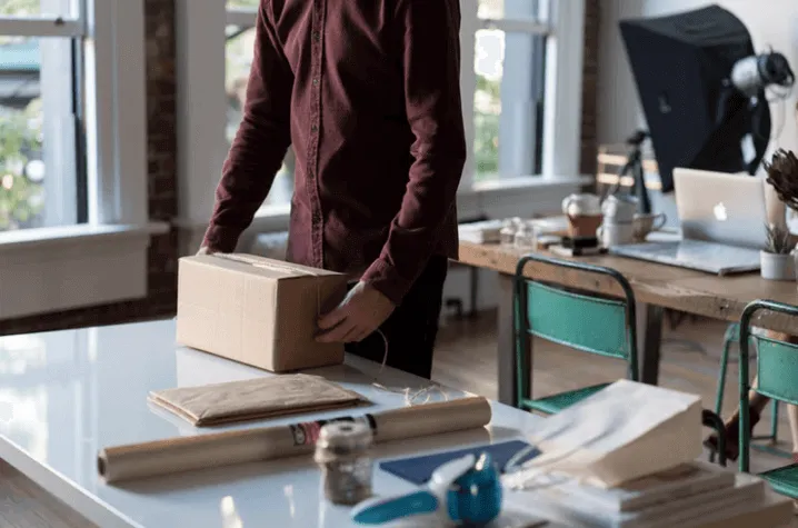 Tip 1 Man Packing a Box on a Desk