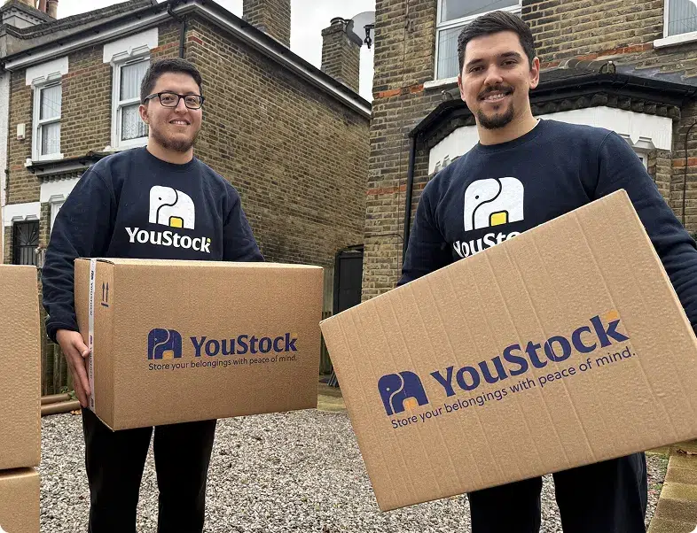 Two YouStock removal men carry a storage box
