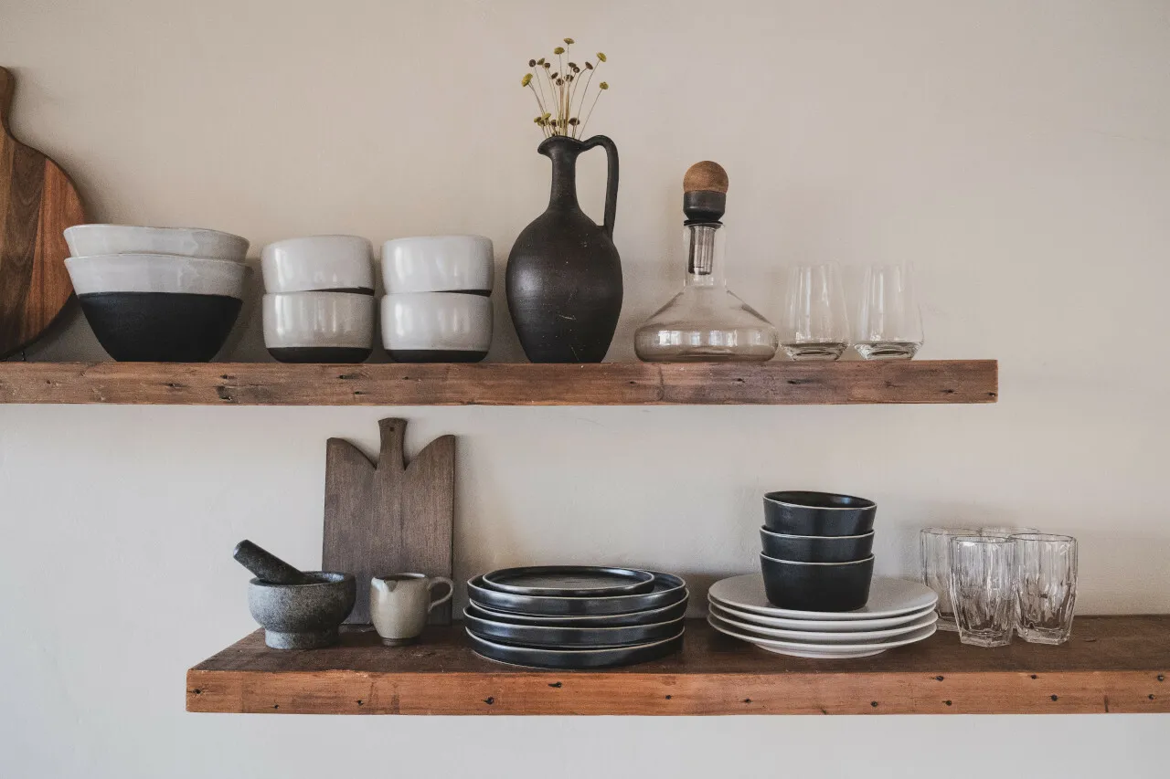 Etagères en bois remplies de vaisselles et d'ustensiles de cuisine