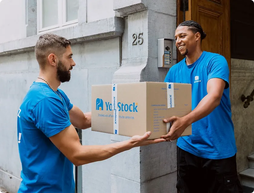 Deux professionnels YouStock se transmettent un carton de stockage