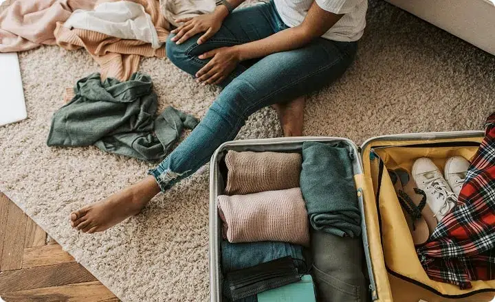 Une jeune femme fait sa valise