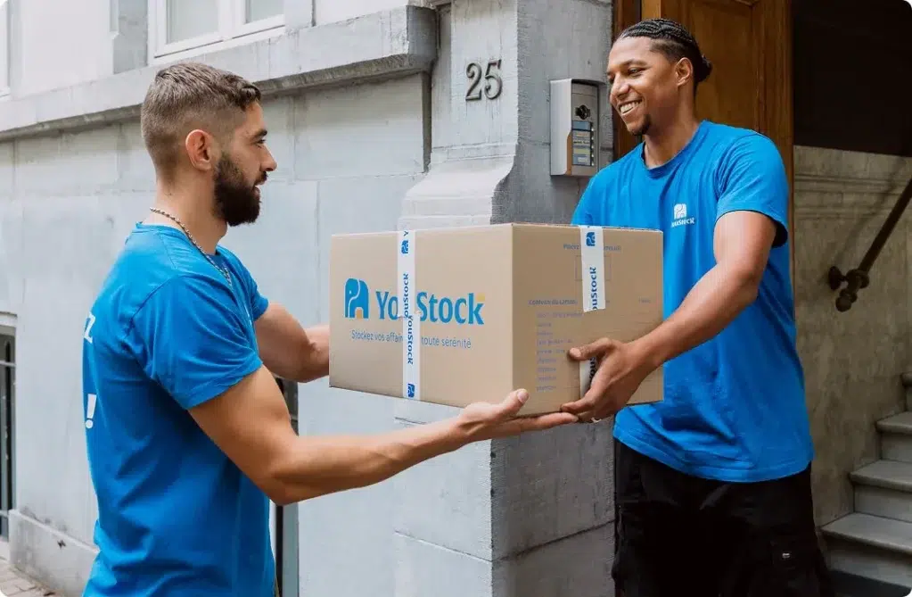 Deux professionnels YouStock se transmettent un carton de stockage