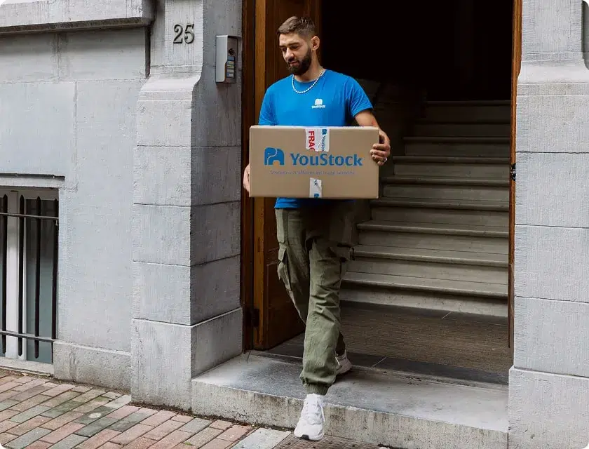 Professsionnel YouStock portant un carton de stockage à la main