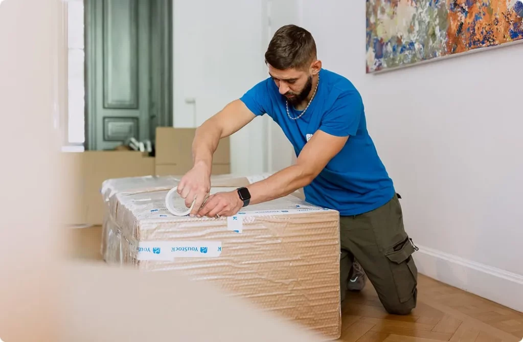 A removal professional tapes a box