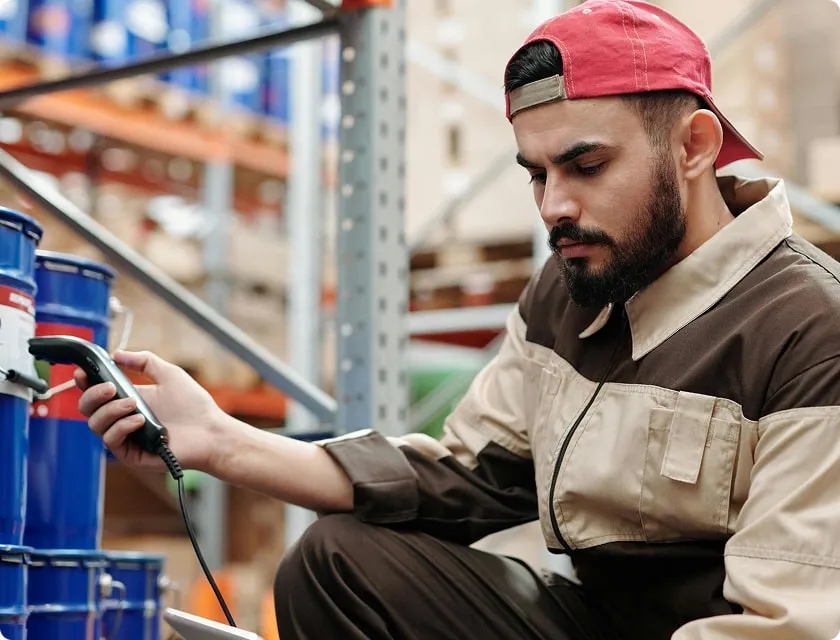 Man scanning and inventorying a drum in a warehouse