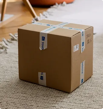 Carton de déménagement YouStock fermé et posé au sol.