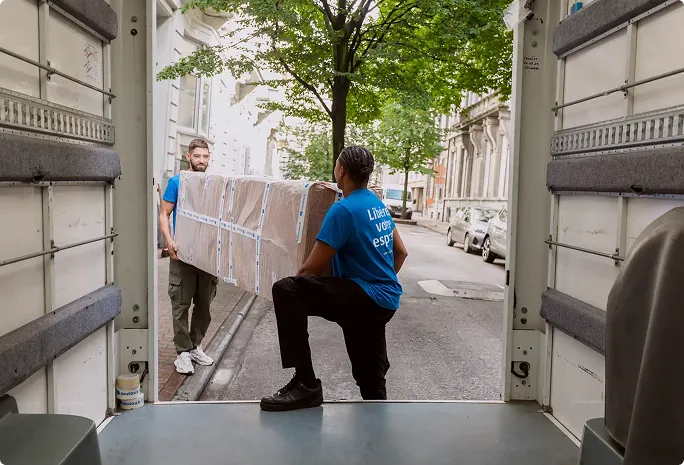 déménageurs YouStock qui portent un grand carton