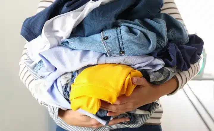 person holding a pile of clothes