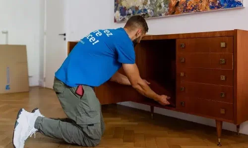 Déménageur YouStock démontant un meuble bas précieusement