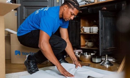 A removal professional wraps and protects crockery